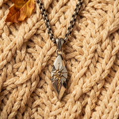 Sigil Quicksilver necklace arranged over a beige knit