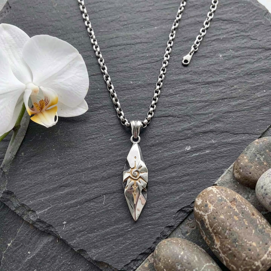 Sigil Quicksilver necklace arranged on slate beside a white orchid