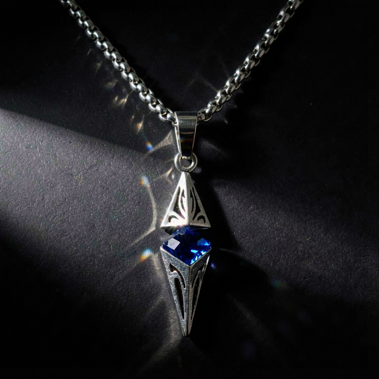 Axis Cobalt necklace styled on folded dark fabric with a light flare