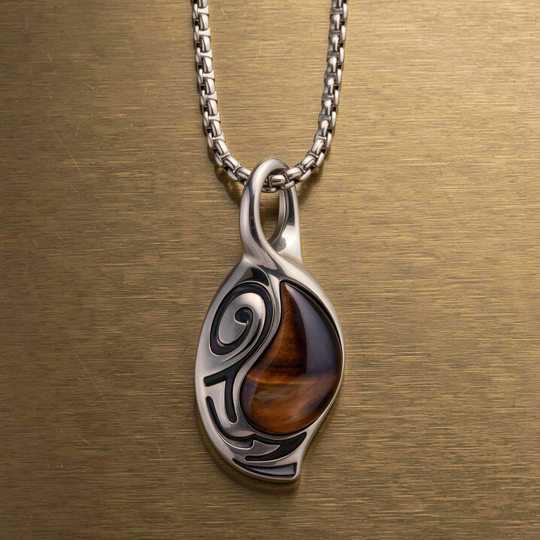 Vortex Ember pendant presented against a warm brass surface