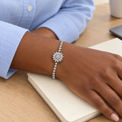 Blossom Silver bracelet worn with a blue shirt beside a notebook