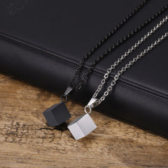 Cube necklaces in Black and Silver arranged together on leather and timber