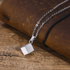 Cube Silver necklace arranged on a leather notebook and timber