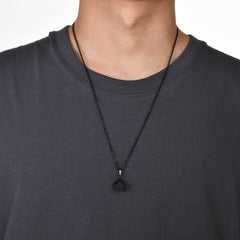 Cube Black necklace worn over a black crew-neck shirt