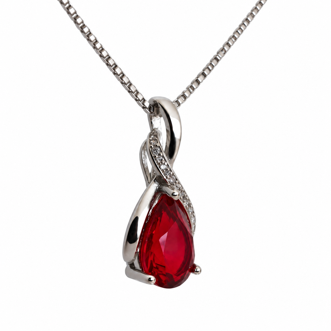 Drop Scarlet necklace from a slight side angle, showing the faceted red centre and flowing silver frame