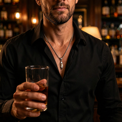 Sigil necklace worn with a black shirt in a low-lit bar