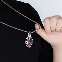 Vortex Ember necklace held by the chain against a black shirt