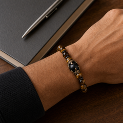 ZAFT Crest Forge tiger-eye bracelet worn at a creative studio desk