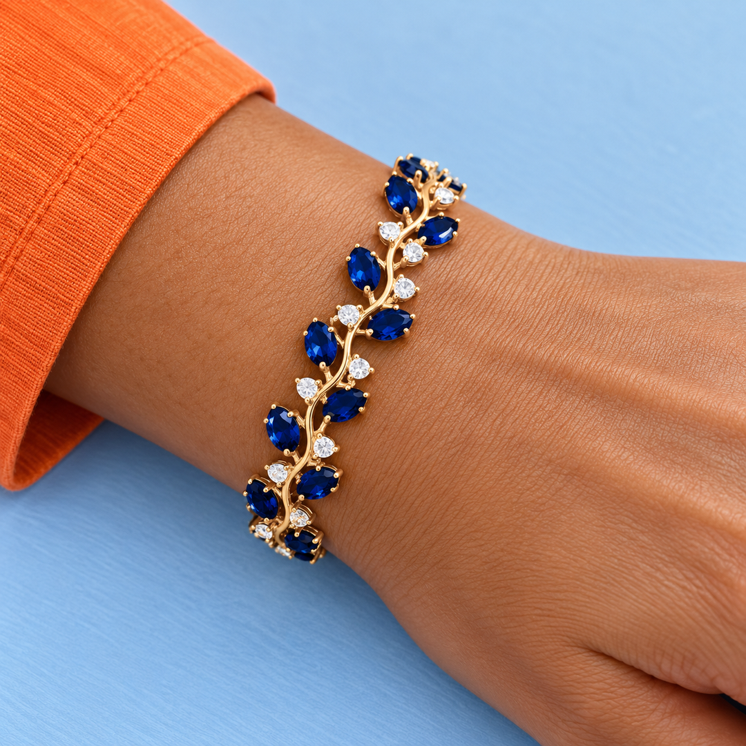 Close worn view of Eden in Cobalt with a gold-tone finish beside a tangerine sleeve.