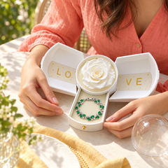 Eden Fern Silver-tone bracelet in an open White Rose Box, held at a sunlit garden table