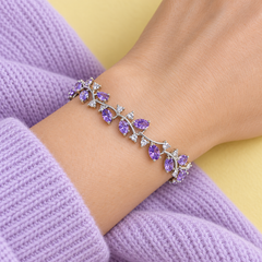 Close worn view of Eden in Violet with a silver-tone finish beside lilac knitwear.