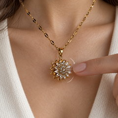 A fingertip gently turns Flora Gold's upper flower; curved arrows illustrate the rotating face