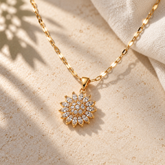 Flora Gold pendant detail on pale stone in warm morning light