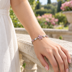 One Floret pink floral bracelet worn with an ivory linen dress on a garden terrace