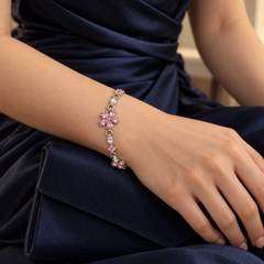 One Floret pink floral bracelet worn with a navy dress and clutch