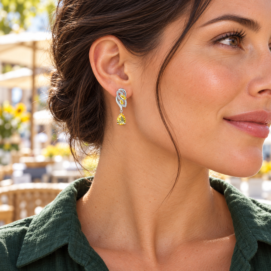 Iris Drop Earrings in Citron, worn on a pierced ear with the silver leaf setting and faceted pear-shaped drop visible