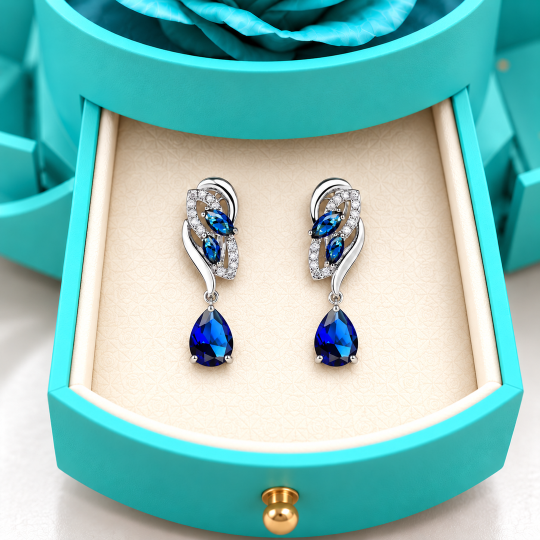 Close view of Iris Cobalt Silver earrings in the ivory drawer insert of the light blue Rose Box