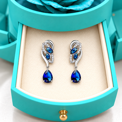 Close view of Iris Cobalt Silver earrings in the ivory drawer insert of the light blue Rose Box