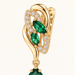 Macro view of Iris Forest Gold leaf setting and two green marquise-shaped stones