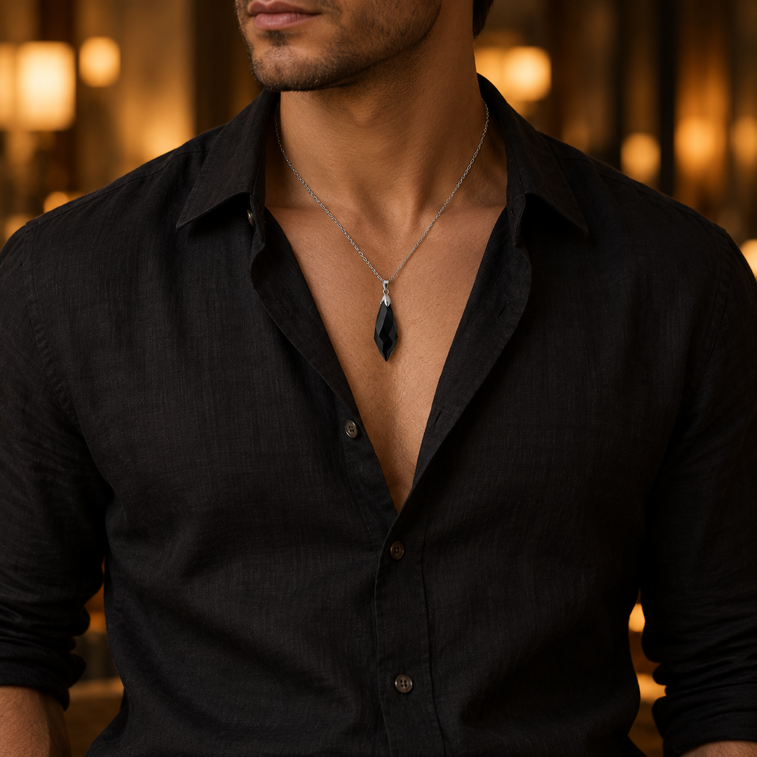 Meteor Black necklace worn with an open black linen collar, showing its compact pendant and chain drop