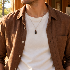 Meteor Mocha necklace worn with an ivory tee with a brown linen overshirt, showing its compact pendant and chain drop