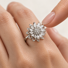 Petal silver flower turning with a gentle fingertip touch — motion illustrated