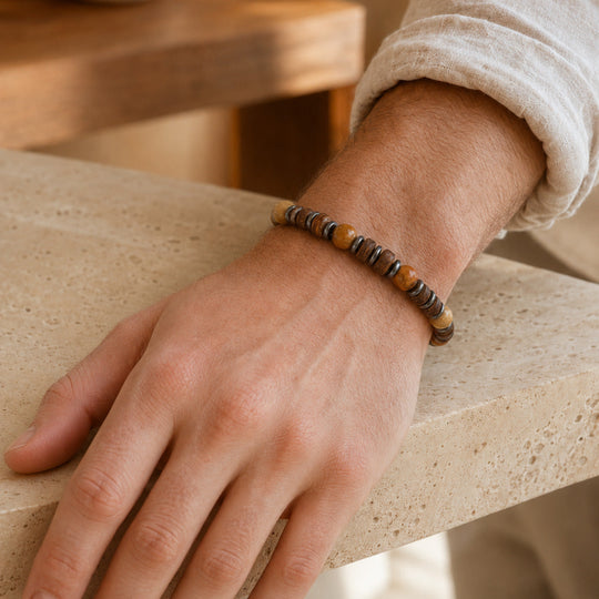 Relic Dune bracelet worn with a linen cuff beside warm travertine