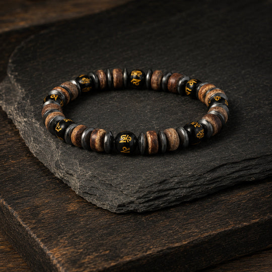 Relic Rune bracelet arranged on layered slate and dark timber