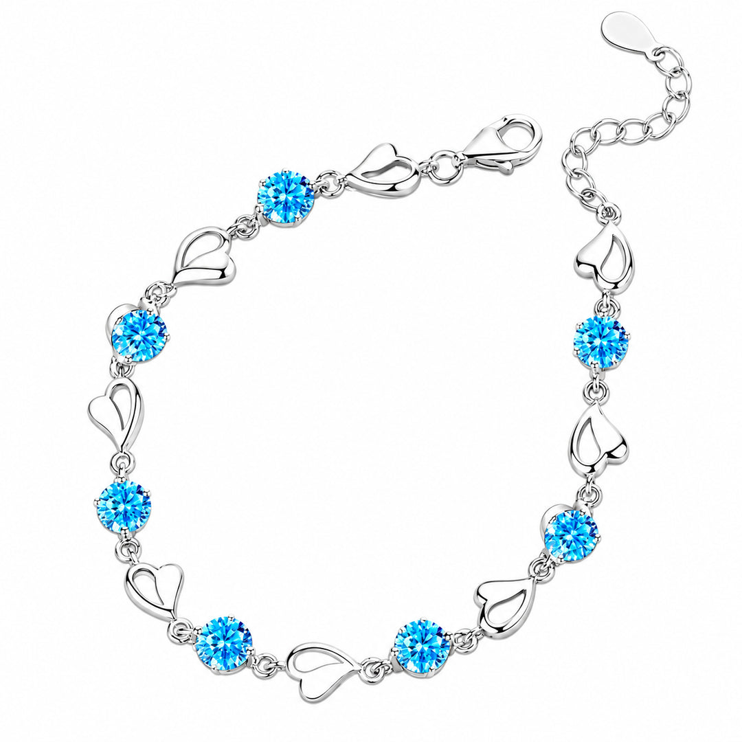 Skye bracelet with blue stones and alternating silver open-heart links on white