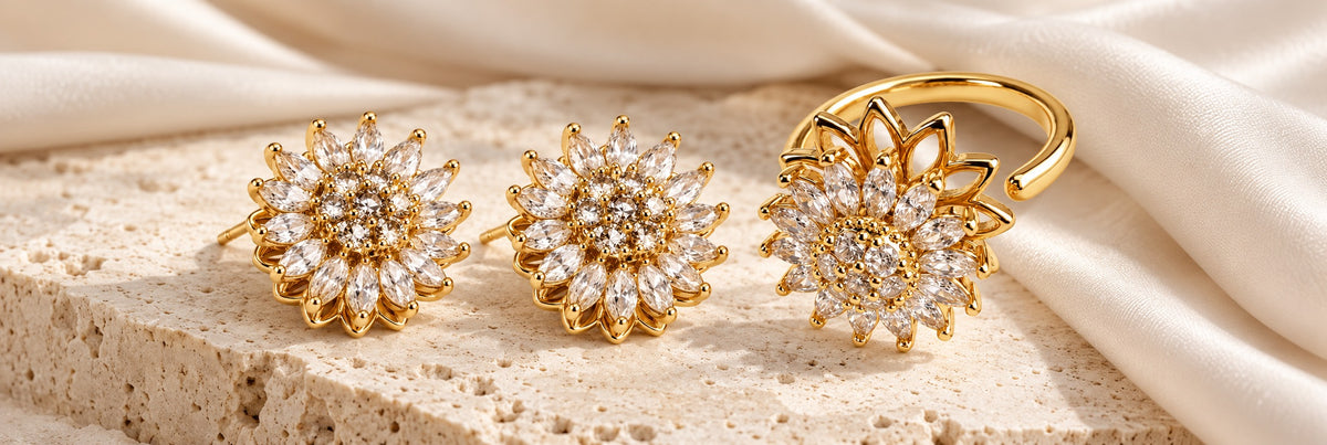 Bloom Clear Gold earrings and Petal Gold ring on ivory stone