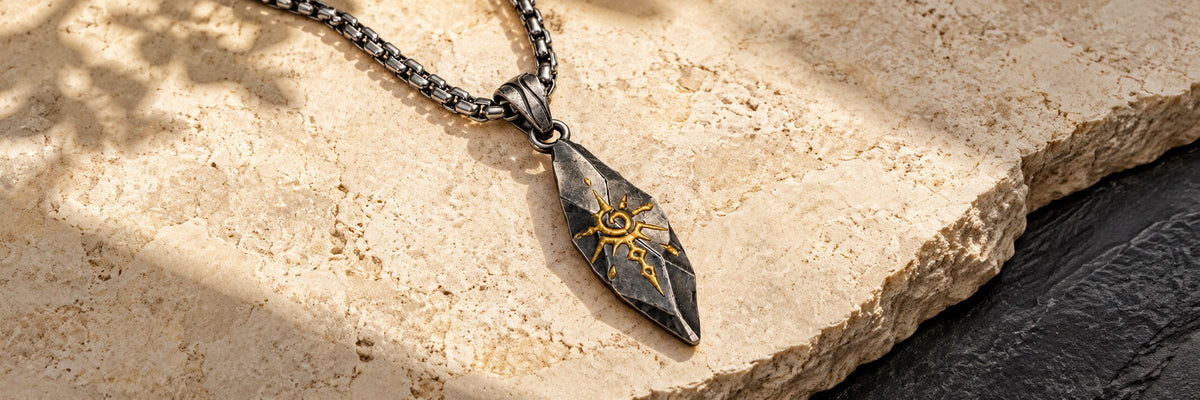 Sigil Graphite necklace on warm limestone and charcoal slate
