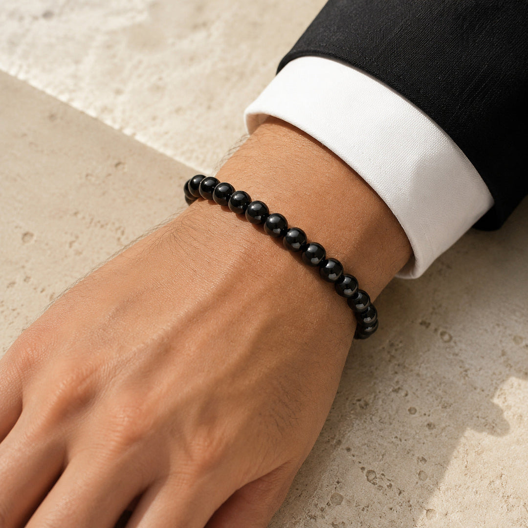 Vestige Noir glossy black hematite bracelet worn with tailoring