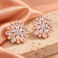Dahlia Rose clear-stone pair in a rose-gold-tone setting on pale stone